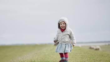Germany Schleswig Holstein Eiderstedt happy little girl standing on dyke model released Symbolfot