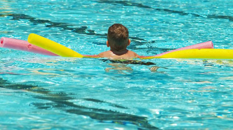 boy using pink and yellow floats in a swimming pool Copyright: xLorixSparkiax/xDesignxPicsx , 30294528 PUBLICATIONxINxGE