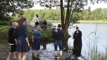 Die Taufgesellschaft bringt die Kinder für die Taufe zu Pastor Cornelius Wergin ins Wasser