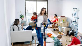 Mother cleaning house with family in living room at home model released, Symbolfoto property released, JJF00964