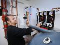 Themenfoto Heizungstausch. Heizungsbauer nimmt nach Einbau einer Waermepumpe Einstellungen vor. *** Theme photo heating 