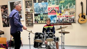 Pascal macht unter der Anleitung von Kai-Uwe Müller erste Erfahrungen am Schlagzeug