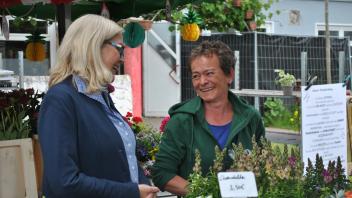 Beata Czampiel (rechts) verkauft auf dem Wochenmarkt in Düsternort Blumen. Sie freute sich über ein kleines Geschenk von Oberbürgermeisterin Petra Gerlach.