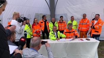 Wollen voneinander lernen: Jens Holmboe vom dänischen Vejdirektoratet (sitzend am Tisch von links) und Stephan Krenz, Chef der Autobahn GmbH bei der Unterzeichnung eines Memorandums.