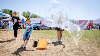 Joe (5) und Lia (11) können kaum fassen, was für super Seifenblasen ihre Mutti Christin produziert. Sie sind aus Groß Klein in den Iga-Park gekommen, um sich einen richtig schönen Sonnabend zu machen...Rostock ist bunt - Bürgerfest im IGA-ParkFoto: Georg Scharnweber