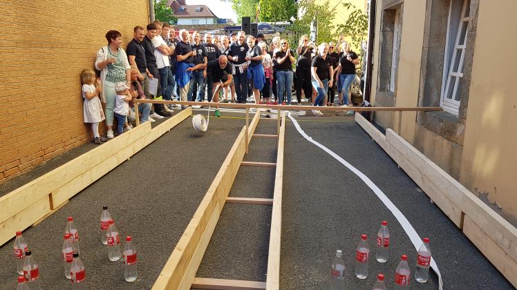 Ein Mann kegelt mit einem Feuerwehrschlauch