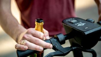 Mit Bier am E-Scooter-Steuer