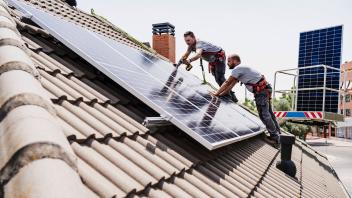 Craftsmen installing solar panels on rooftop of house model released, Symbolfoto property released, EBBF05705