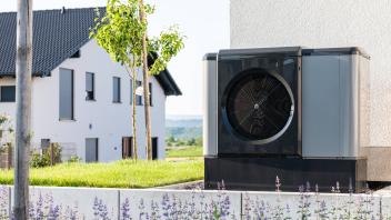Eine Wärmepumpe steht in einem Garten eines Einfamilienhauses in einem Neubaugebiet. Rottweil Baden-Württemberg Deutschl