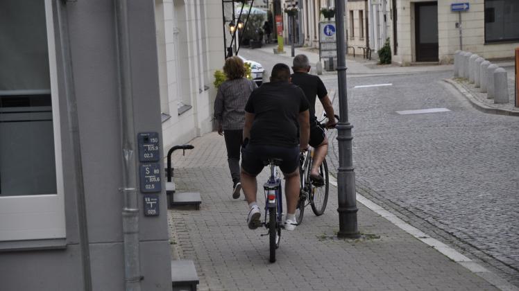 Auch diese beiden Radfahrer fahren auf der falschen Straßenseite auf dem Fußweg.