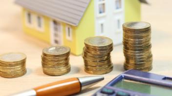 Konzeptfoto mit Modelhaus und Geldmünzen *** Concept photo with model house and money coins