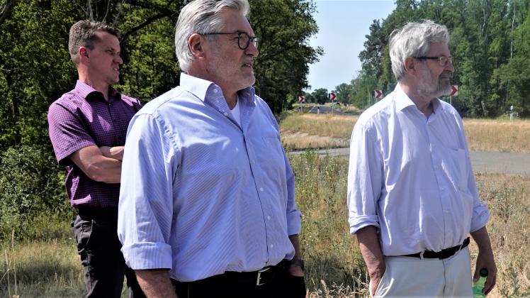 Bernd Lindow (M.), Sachbereichsleiter Umwelt des Landkreises Prignitz, und Umweltminister Axel Vogel (Grüne) (r.) stehen auf dem kleinen Breeser Deich.  