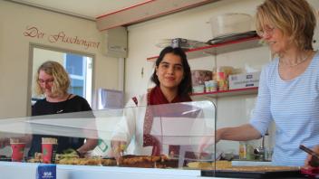 Drei Frauen verkaufen selbst gemachten Kuchen auf dem Sommerfest der Flüchtlingshilfe in Lotte.
