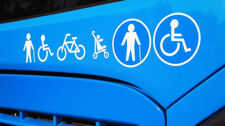 Disabled sign, elderly people, baby carriage and bicycle icons on city bus. Public transportation accessibility concept 