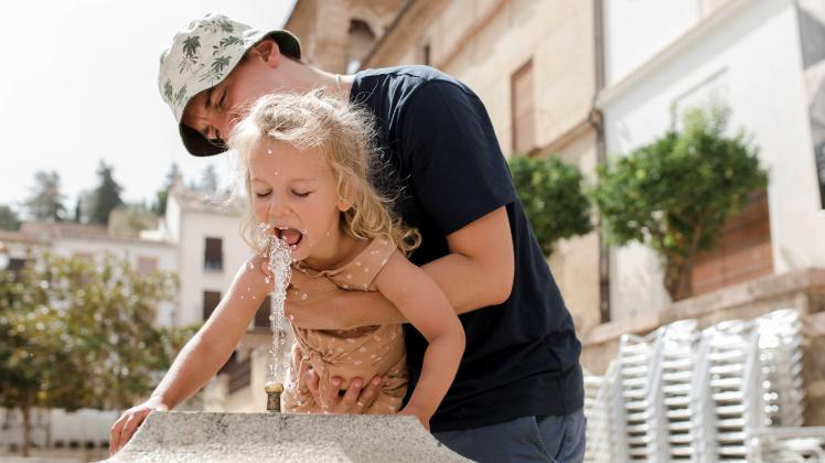 Father with daughter drinking water from fountain model released, Symbolfoto, VIVF00468