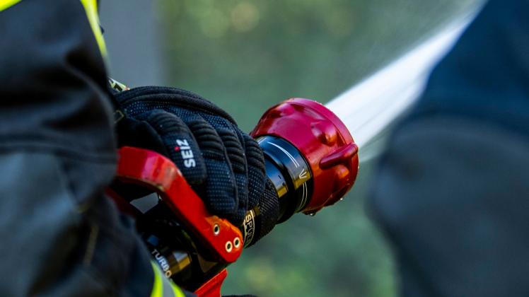 Symbolbilder Feuerwehr Katastrophen, Unfall, Feuerwehr: Ein Feuerwehrmann löscht mit Wasser aus einer Spritze. Wadersloh