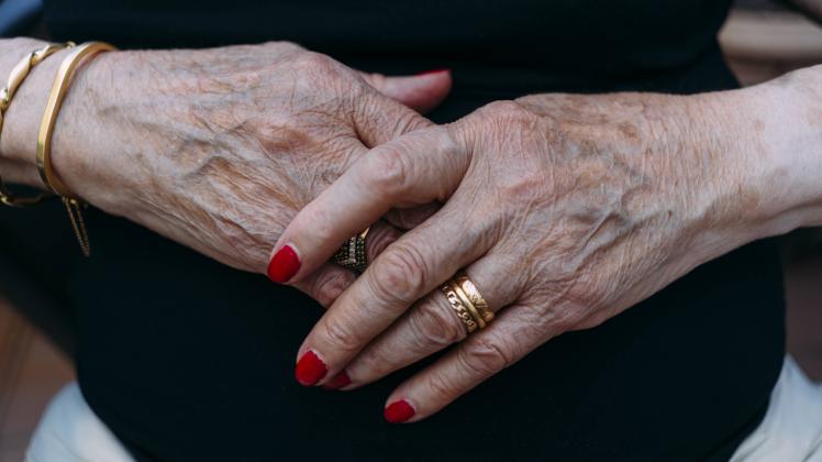 Hands of senior woman with golden rings and red painted nails model released Symbolfoto PUBLICATIONx