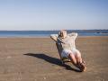 Elderly woman relaxing with hands behind head on deck chair at beach model released, Symbolfoto, UUF28173