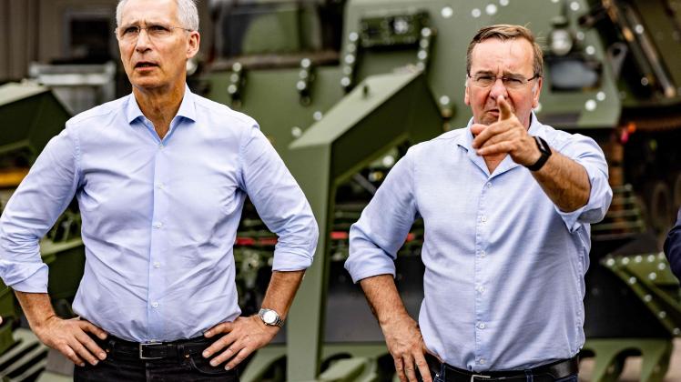 German Defence Minister Boris Pistorius (R) and NATO Secretary General Jens Stoltenberg stand in front of a mine clearance tank on the grounds of the military technology company FFG (Flensburger Fahrzeugbau Gesellschaft) in Flensburg, northern Germany, on June 20, 2023. (Photo by Axel Heimken / AFP)