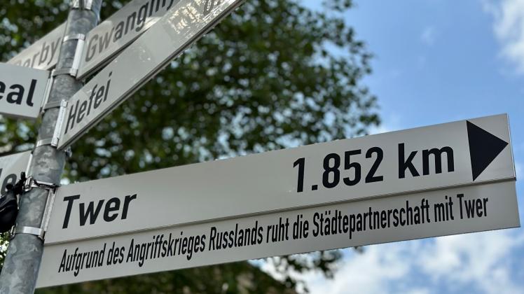 Der Wegweiser nach Twer auf dem Platz der Städtefreundschaften in Osnabrück ist durch ein Zusatzschild ergänzt worden: „Aufgrund des Angriffskriegs Russlands ruht die Städtepartnerschaft mit Twer.“