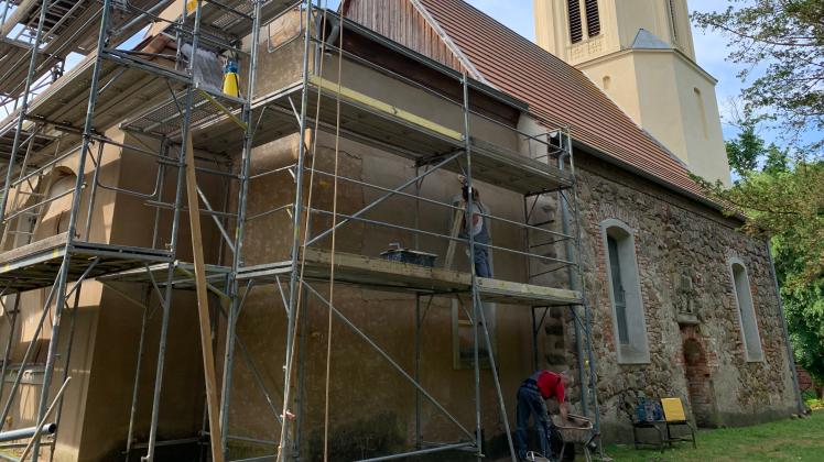 Das Kirchenschiff der Patronatskirche in Stavenow ist eingerüstet. Mitarbeiter der beauftragten Baufirma rücken dem teils bröckelnden Mauerwerk zu Leibe.