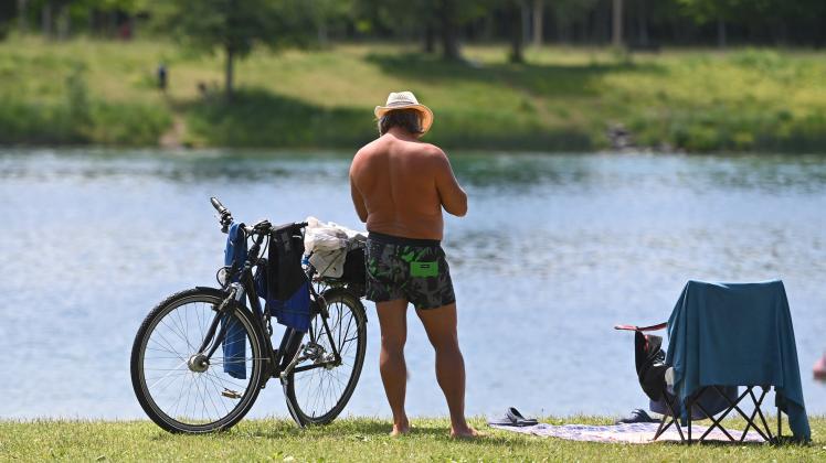 Mann in Badehose und mit Strohhut chillt am Riemer See,Freizeit,Erholung,Sommer,Fahrrad,Campingstuhl,baden,Badesee *** M