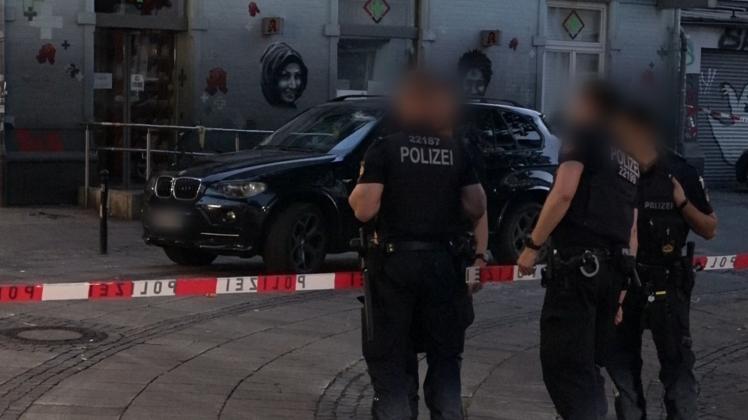Polizisten stehen im Bremer Steintor-Viertel vor dem attackierten BMW des Ehepaars.