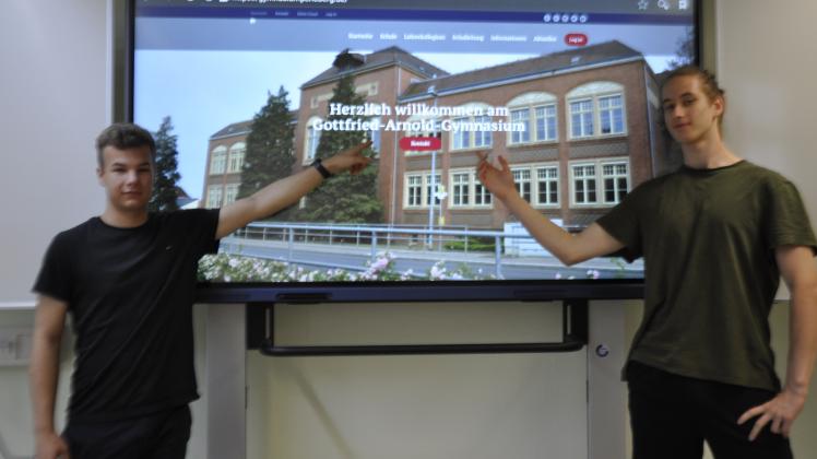Edgar Stütz und Morten Stibbe zeigen die Startseite der künftigen Schulwebseite des Gottfried-Arnold-Gymnasiums.