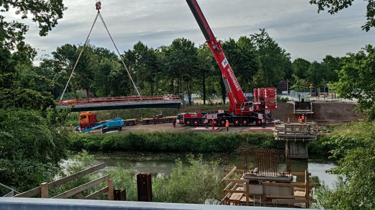 Mit einem mobilen Schwerlastkran der Firma Wagenborg wurden die Brückenteile, die mit mehreren Schwertransportern nach Haselünne gebracht worden waren, an ihren Bestimmungsort über der Hase gehoben.