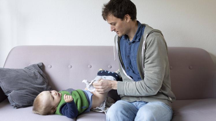 Thema: Vater wickelt ein Kind im Alter von neun Monaten mit Stoffwindeln Bonn Deutschland *** Subject father swaddles a