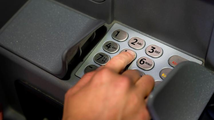 Hand an einem Geldautomaten, Eingabe der Geheimzahl, Geldabheben *** Hand at an ATM, entering the secret code, withdrawi