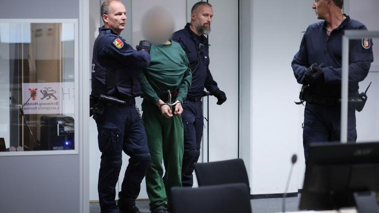 Defendant Ibrahim A (2L) is led by judicial officers to his place in the dock of the courtroom at the China Logistic Center for his trial for the fatal knife attack in a regional train in Brokstedt, Schleswig-Holstein, on January 25, 2023, at the District Court in Itzehoe, northern Germany on July 7, 2023. German prosecutors in April 2023 charged the stateless man of Palestinian origin with two counts of murder over a knife attack on a train in January that killed two teenagers. Having previously ruled out a "terrorist" motive in the rampage that also wounded several other passengers, the prosecutor's office in the northern town of Itzehoe said in a statement the assailant had acted "out of anger about his in many ways unresolved personal situation". In addition to the murder charges, he faces four counts of attempted murder. The 33-year-old suspect named only as Ibrahim A. allegedly went on the stabbing spree on January 25 on a train travelling between the northern cities of Hamburg and Kiel. (Photo by Christian Charisius / POOL / AFP)