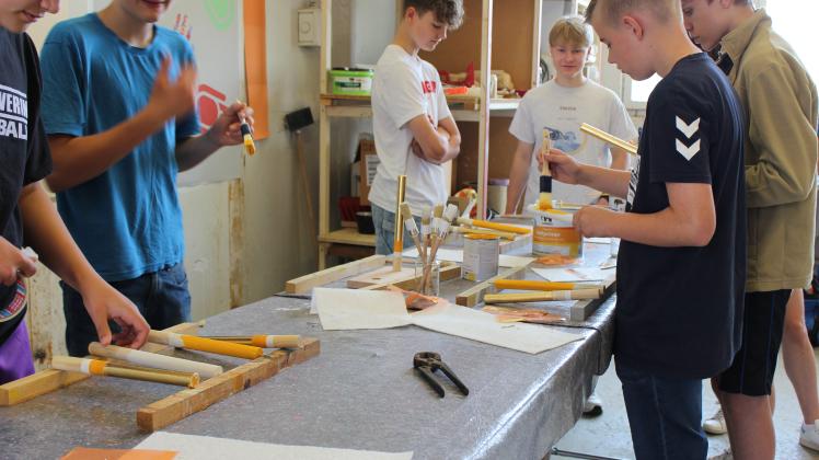 Schüler vergolden Holz beim Workshop