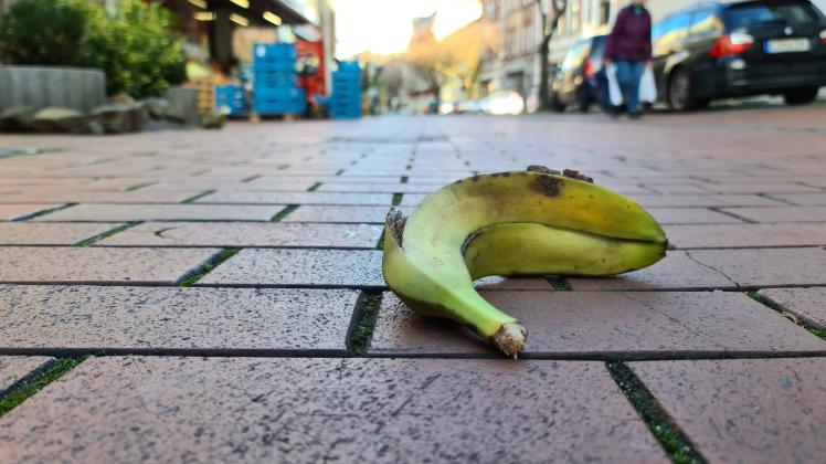 verrottende Bananenschale in einer Spielstrasse, Deutschland rotting banana peel in a play street, Germany BLWS638580 **