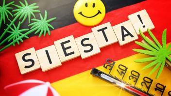 Schriftzug Siesta! auf einer Deutschlandfahne *** Writing Siesta on a flag of Germany