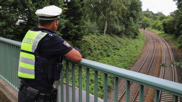 Von einer Brücke aus kontrolliert ein Polizeibeamter in Itzehoe die Gleise Richtung Heide. Die Beamten fahnden nach Einbrechern.