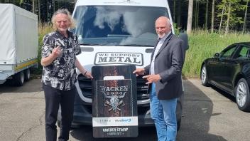 Holger Hübner und Michael Malzahn präsenteren Wacken-Briefmarke in Wacken.