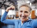 Senior woman, flexing and smile for selfie or profile picture in exercise, workout or muscle training at the gym. Portra
