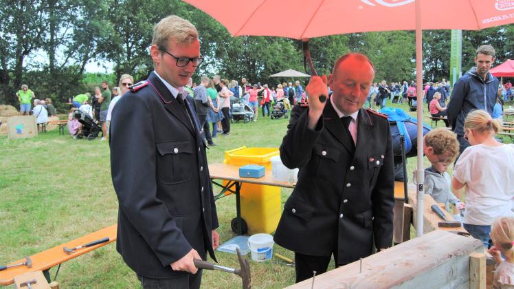 Tjorben Roeloffs und Norbert Clausen am Nagelbock beim Sommerfest der Feuerwehr Borgsum-Witsum