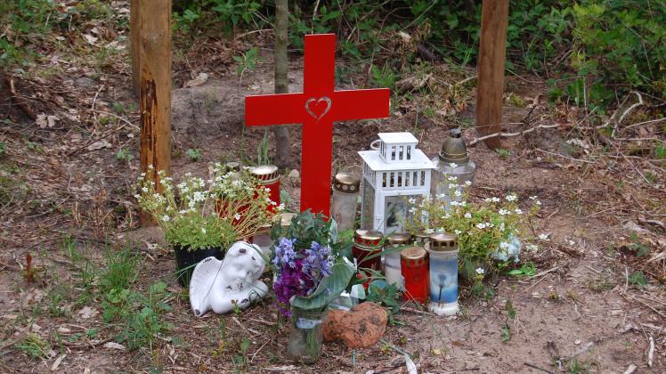 Ein Kreuz und Blumen erinnern an das Opfer im Tötungsdelikt Pente.