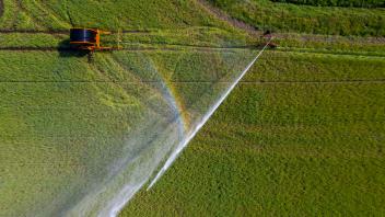 Bewässerung eines Weizenfeldes am Niederrhein, mit einer mobilen Beregnungsmaschine, Grossflächenregner, Deutschland, **