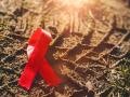 1 March 2023: red ribbon symbol of solidarity with cancer, AIDS and HIV disease. Ribbon on the floor *** rote Schleife S