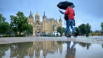 Regenreiche Sommerwoche in MV - gut beschirmt geht es dennoch durch die Landeshauptstadt Schwerin.