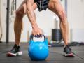 Close up of a muscular man lifting heavy kettlebell Close up of a muscular man lifting heavy kettlebell. High quality ph