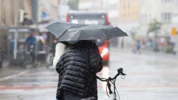 Dauerregen am 03.08.2023 in Osnabrück. Menschen gehen mit Regenschirm am Neumarkt entlang. /Wetter; Jahreszeiten; Niederschlag; Unwetter; Niedersachsen; Regenschirm; Pfütze/ Foto: Michael Gründel