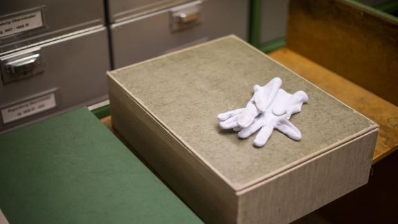 Kiste im Archiv mit Stoffhandschuhen Kiste im Archiv mit Stoffhandschuhen