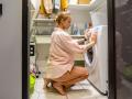 Young woman operating washing machine at home model released Symbolfoto property released VPIF03815