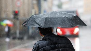 Dauerregen am 03.08.2023 in Osnabrück. Menschen gehen mit Regenschirm am Neumarkt entlang. /Wetter; Jahreszeiten; Niederschlag; Unwetter; Niedersachsen; Regenschirm; Pfütze/ Foto: Michael Gründel