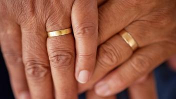Support, trust and love of a senior married couple hands with rings and are in love for many years. Closeup of mature lo