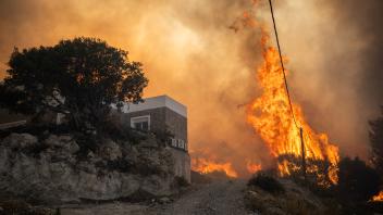 TOPSHOT - A photo shows a fire as it burns vegetation into the village of Gennadi on the Greek Aegean island of Rhodes, on July 25, 2023. Wildfires have been raging in Greece amid scorching temperatures, forcing mass evacuations in several tourist spots including on the islands of Rhodes and Corfu. (Photo by Angelos Tzortzinis / AFP)